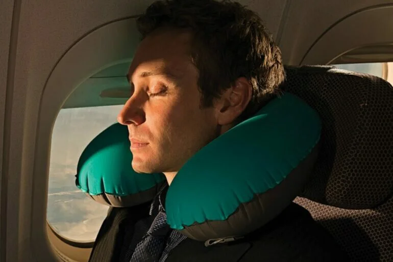 người đàn ông đang đeo gối hơi Sea To Summit cao cấp khi đi máy bay